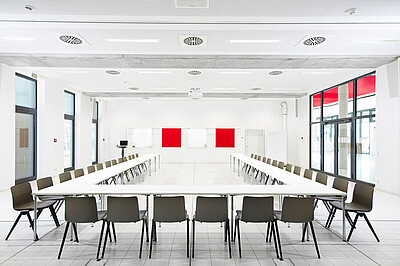 Blick in einen der zwei großen Lernräume, Konferenzbestuhlung, Tische und Stühle in U-Form angeordnet.