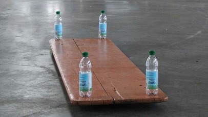 Zusammengeklappter Biertisch auf dem an jeder Ecke eine 0,5 Liter Wasserflasche steht