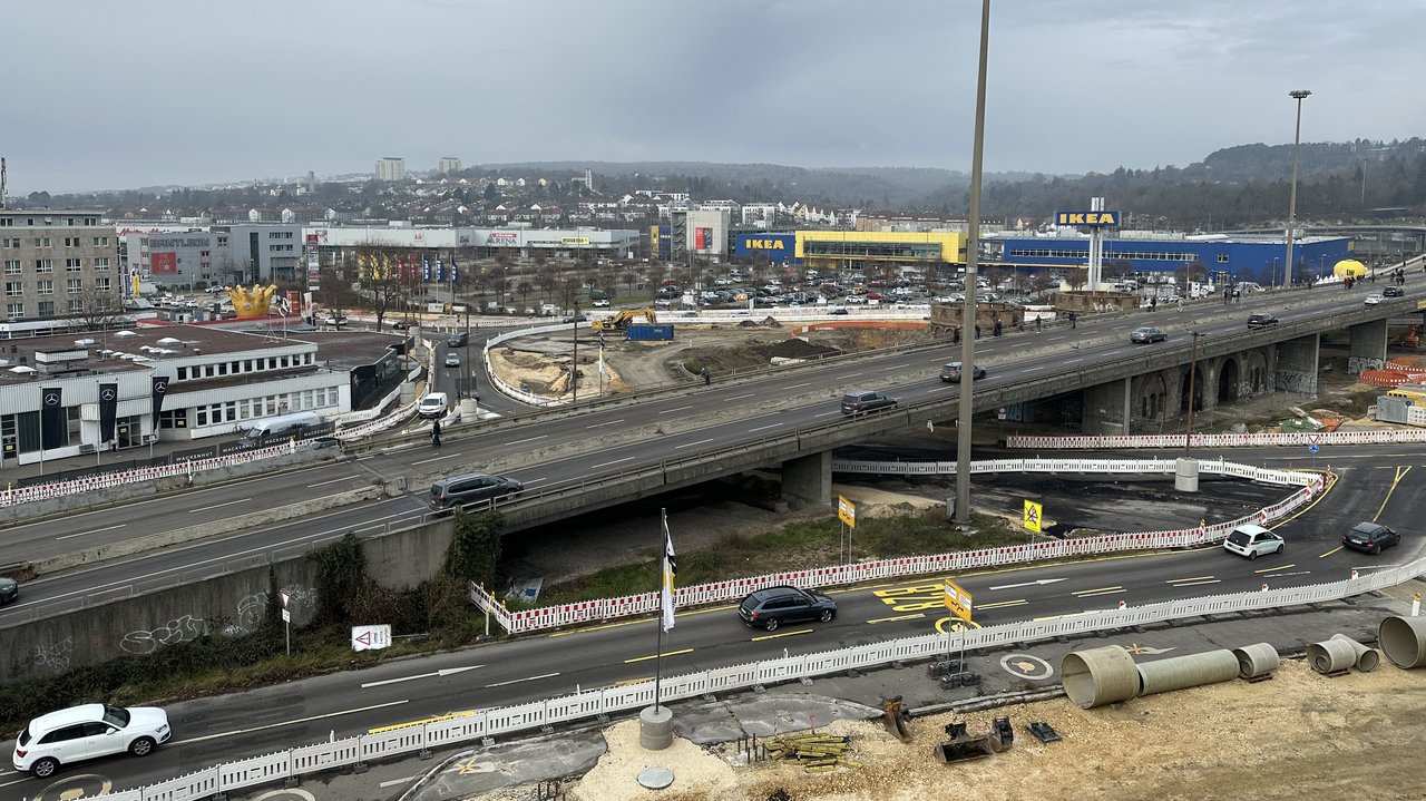 Das Foto zeigt Straßenbaumaßnahmen an der B 10 in Ulm. Im Hintergrund Industriegebäude und Wohnhäuser.