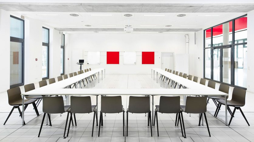 Blick in einen der zwei großen Lernräume, Konferenzbestuhlung, Tische und Stühle in U-Form angeordnet.