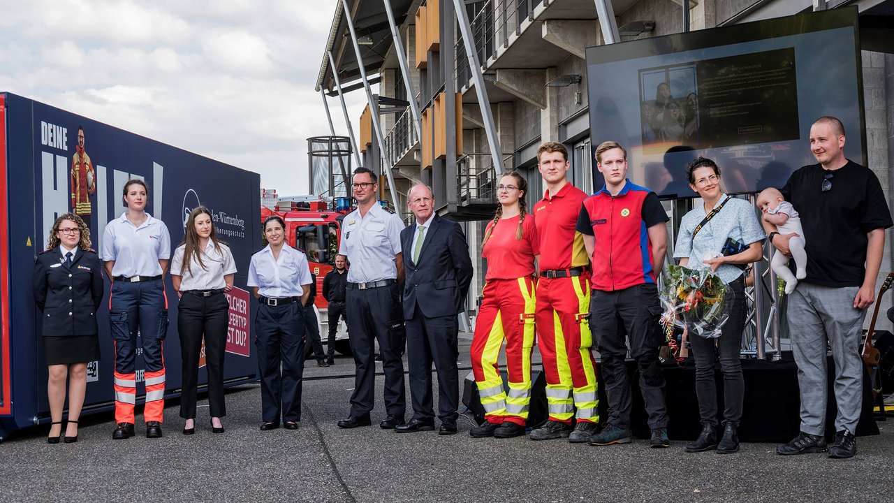 Wilfried Klenk vor dem Werbemobil mit den mitwirkenden aus dem Bevölkerungunsschutz wie Feuerwehr, Rettungsdienst, DLRG und Bergwacht