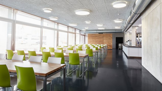 Tische und Stühle im Speisesaal und Blick auf die Ausgabetheke