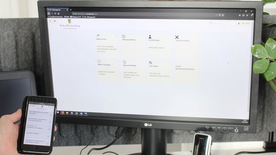 Computerbildschirm der die Anmeldemaske des Bildungsportal zeigt und daneben ein Handy mit der gleichen Anmeldemaske