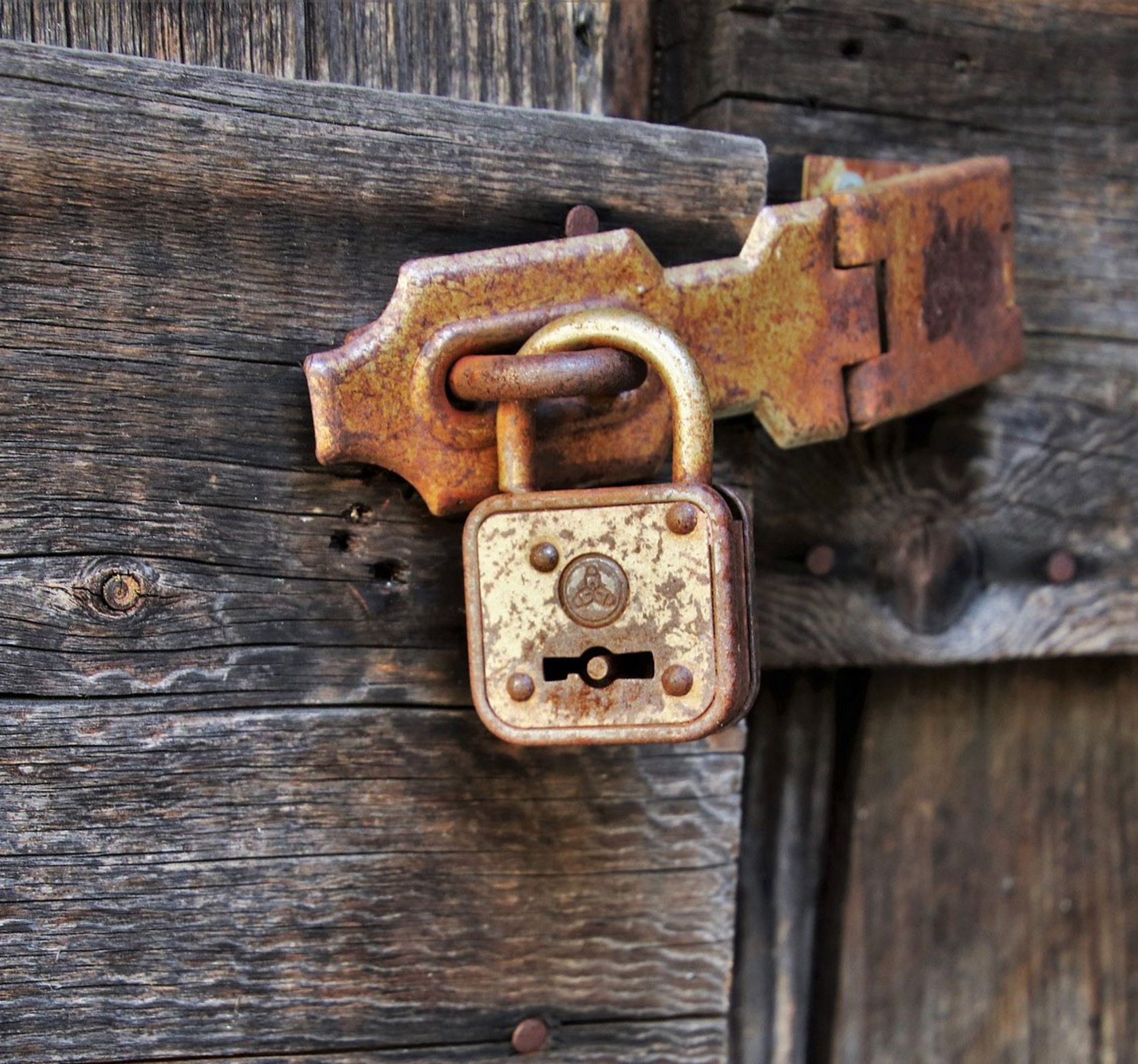 Holztor verschlossen mit einem Vorhängeschloss
