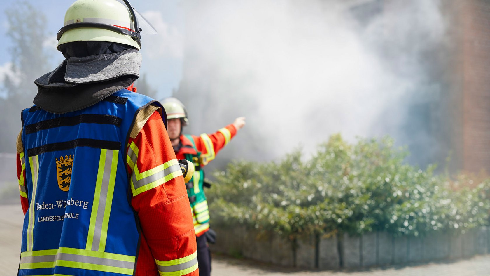 Einsatzkräfte bei einer Übung vor dem Feuerwehr-Übungshaus