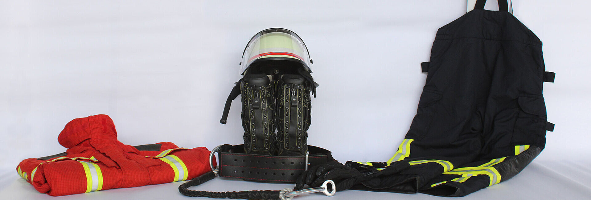 Jacke, Helm, Hose, Gurt und Stifel einer Schutzausrüstung