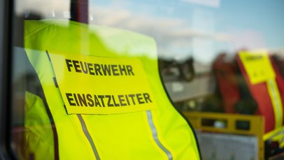 Die Weste für einen Feuerwehr-Einsatzleiter hängt über dem Sitz eines Einsatz-Fahrzeuges