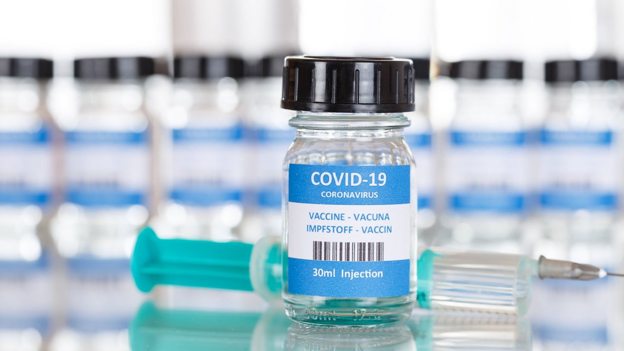 Impfstoffampulle vor einer Spritze