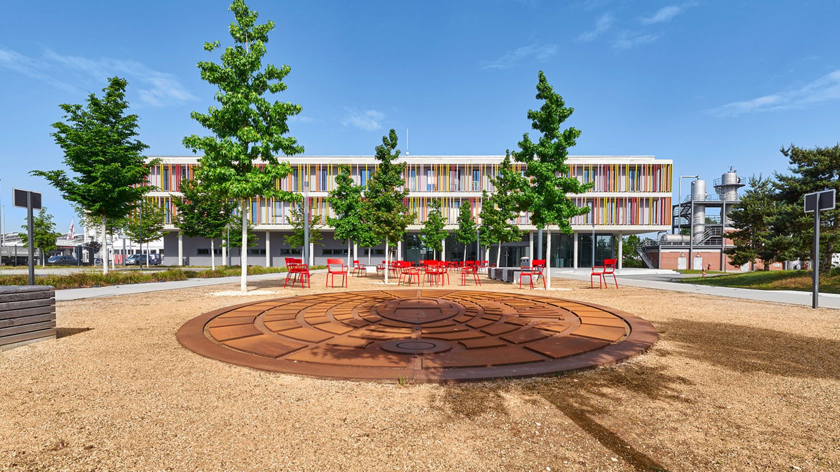 Blick auf den Platz des Unterflurhydranten im Hintergrund das Gebäude 2 "Lernen & Büro"