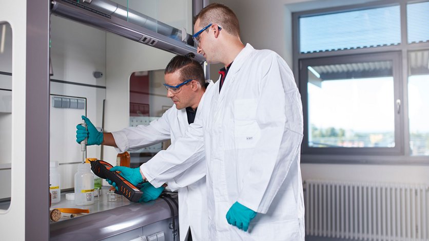 Zwei Lehrgangsteilnehmer an einem Laborarbeitsplatz in Gebäude 4 / Feuerwehrübungshalle