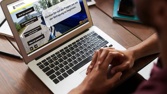 Eine Person vor einem Laptop mit einem geöffneten E-Learning