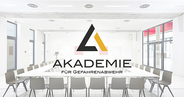 In U-Form bestuhlter Seminarraum der Akademie mit überblendetem Logo