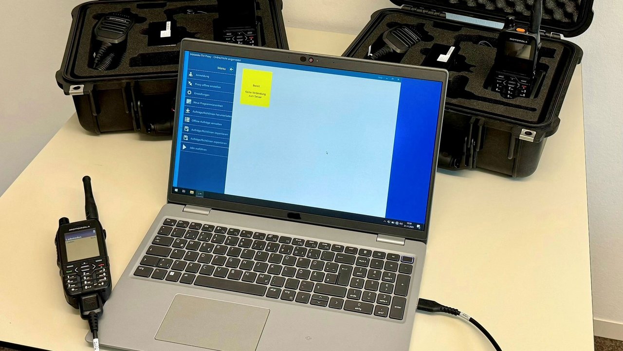 Laptop auf einem Tisch an dem mit einem Kabel ein Funkgerät angeschlossen ist