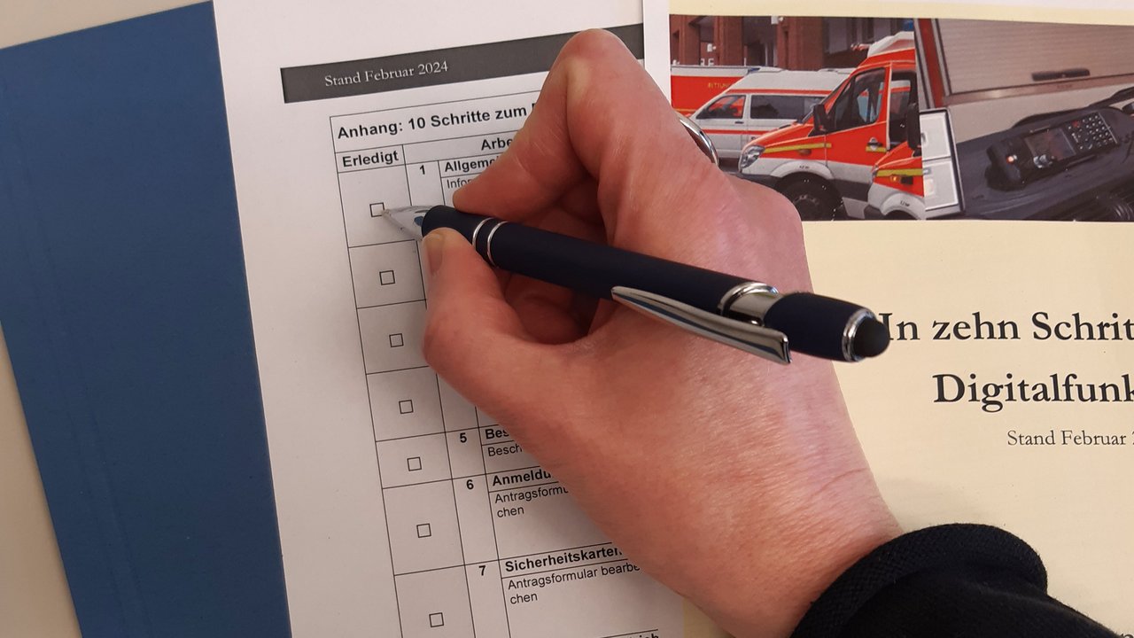 Eine Hand die einen Stift hält und ein Formular ausfüllt