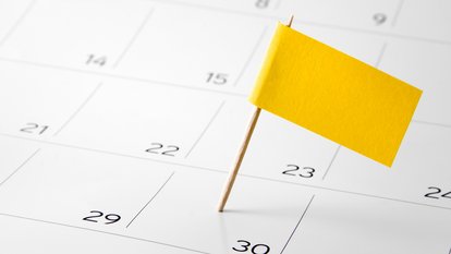 Auf einem Wandkalender ist eine Tag mit einer gelben Steckflagge markiert